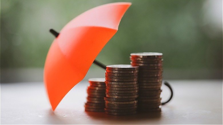 Umbrella over wooden people figurines