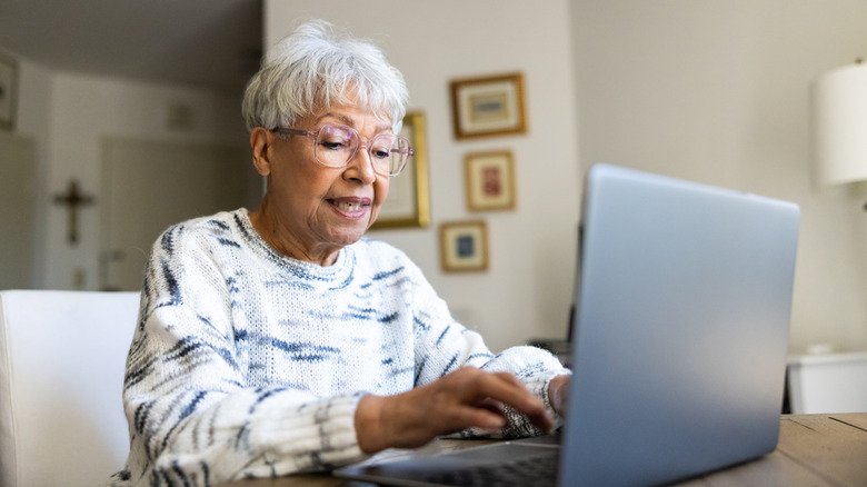 mature woman typing on laptop at home