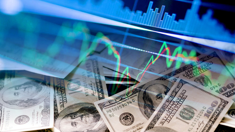 Hundred dollar bills and stock indicators