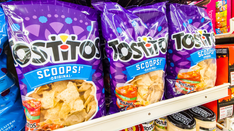 Bags of Tostitos brand tortilla chips sit on a store shelf