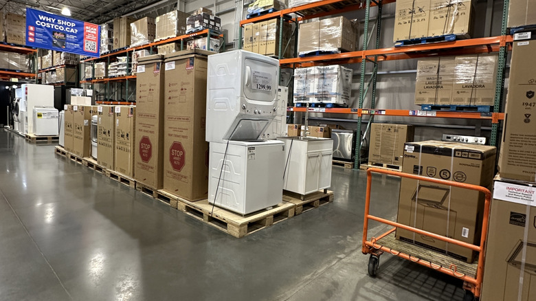 A massive washer dryer set for sale at Costco, surrounded by boxed up items of the same nature