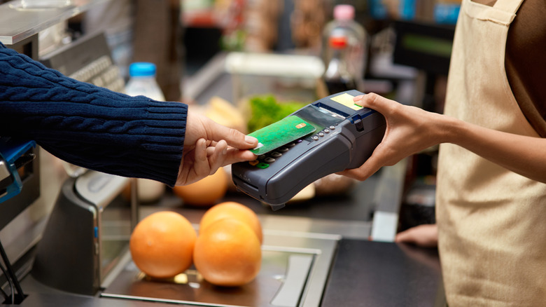 Person paying for groceries with credit card