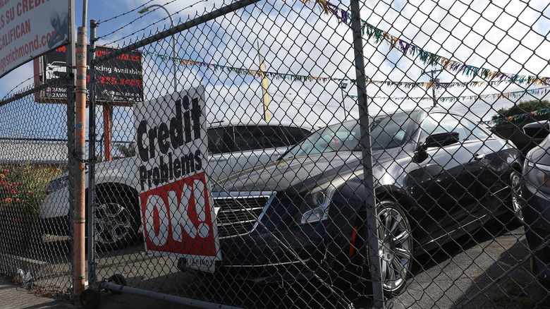 A car sales lot with a sign inviting buyers with bad credit