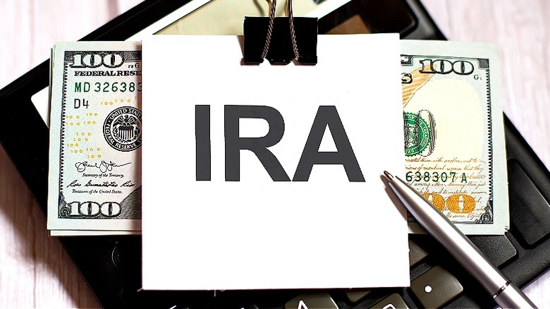 A card with IRA written on it clipped to a stack of money