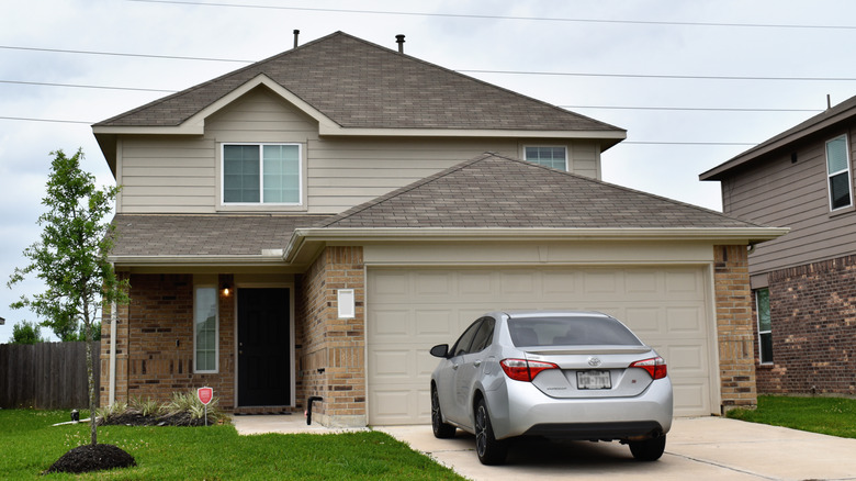 A car parked outside of a suburban home