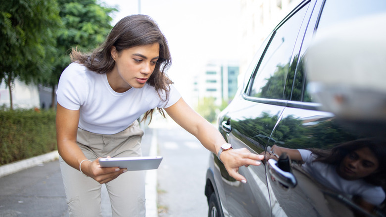 An insurance agent inspecting a vehicle
