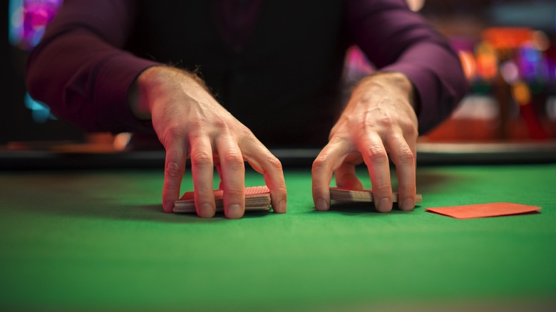 A dealer shuffling cards on a table