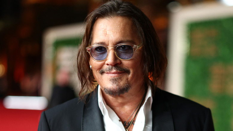 Johnny Depp smiling while wearing sun glasses with blue lens