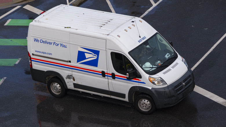 An United States Postal Service (USPS) vehicle drives a route in the rain