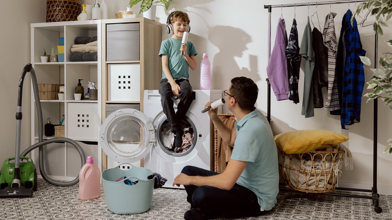 father and son playing in the laundry room