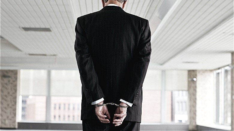 Person in suit in handcuffs
