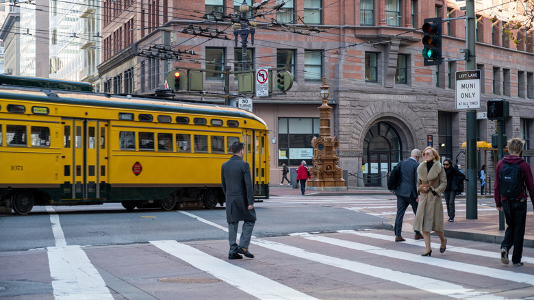Historic streetcar passing pedestrians on San Francisco street