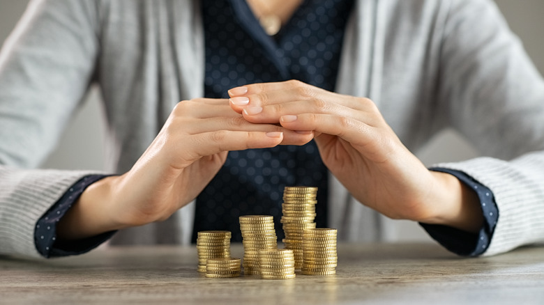 hands covering stacks of coins
