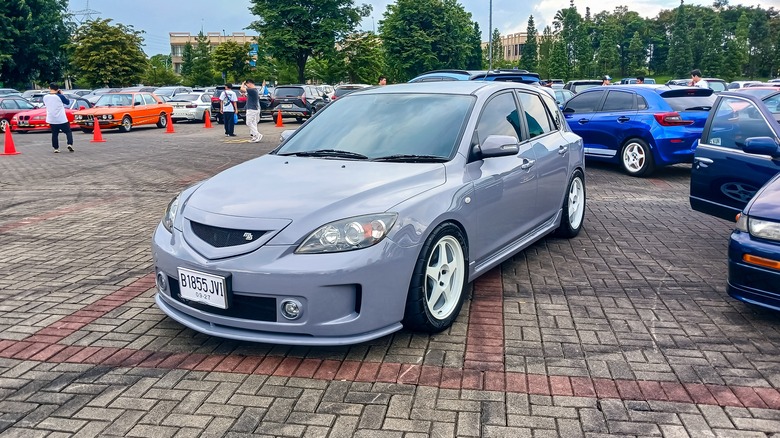 A modifed grey Mazda3 hatchback first generation on The Elite Showcase 2025 outdoor car meet