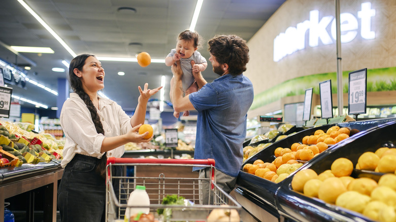 Parents grocery shopping with a baby