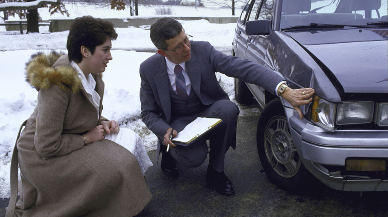 An appraiser from Amica Mutual Insurance Company checks car damage.
