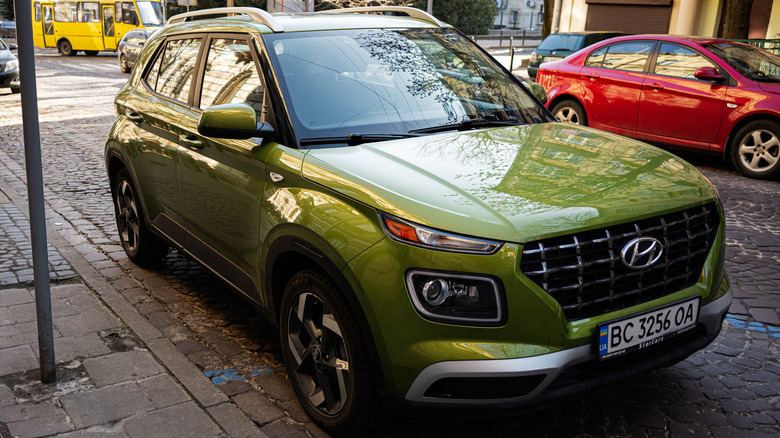 A green Hyundai Venue parked on the side of the road