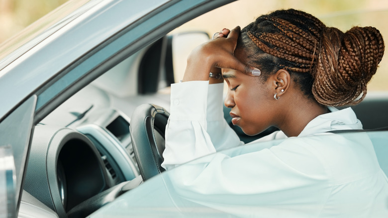 Frustrated young woman sitting in a driver's seat
