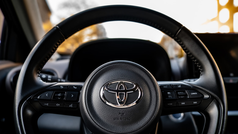 Close-up of a steering wheel with the Toyota logo in the center.