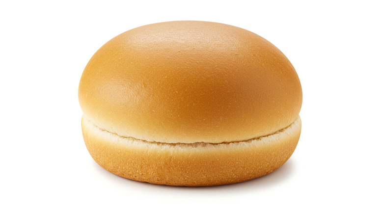 Side view of plain hamburger bun isolated on white background.