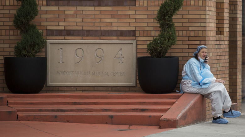 Medical worker sitting next to Wyckoff Heights Medical Center, Brooklyn