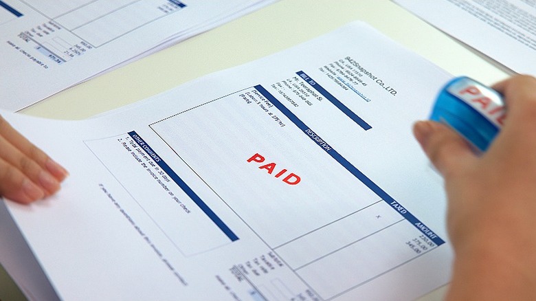 Person stamping bill as paid