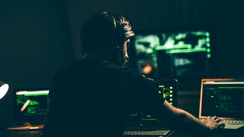Person monitoring multiple computer screens