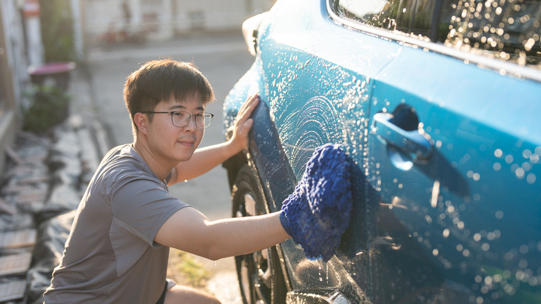 Man hand washing his car