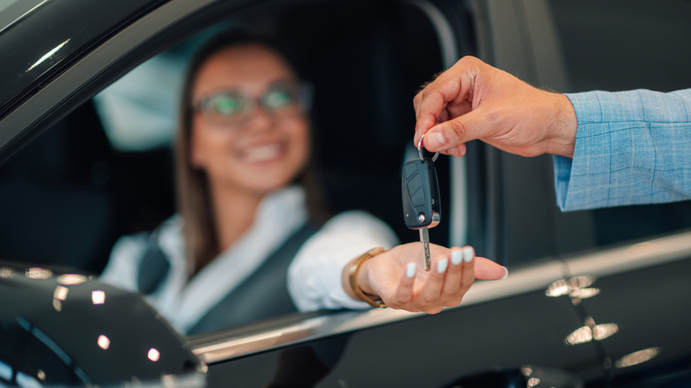 Woman being handed the keys to her vehicle