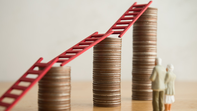 Savings concept illustrated with ladders on stacked coins
