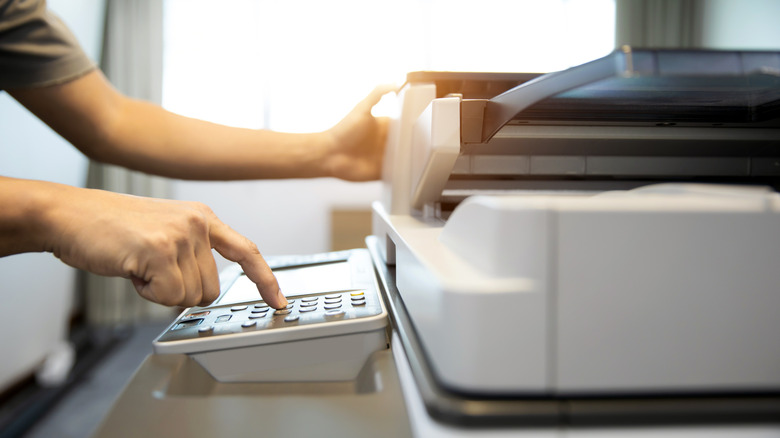 Person using a large office printer machine