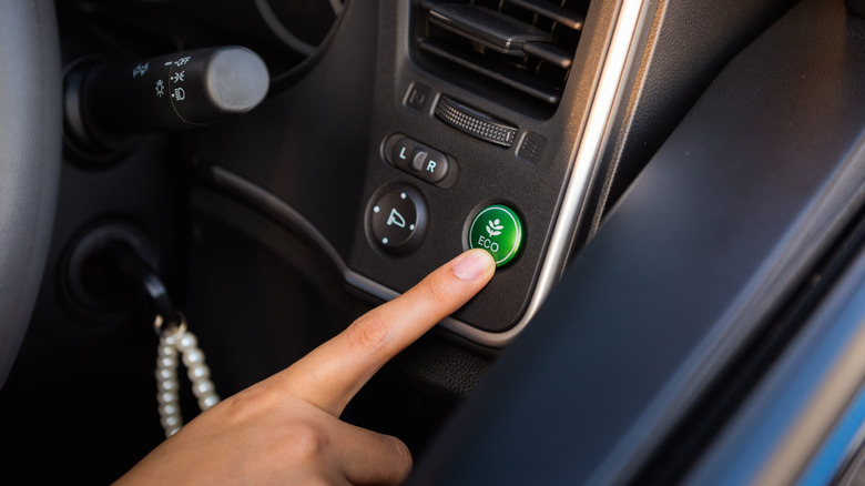 Person activating Eco mode in a car