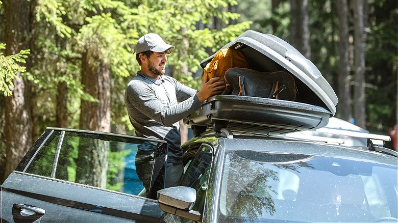 Person using rooftop cargo box