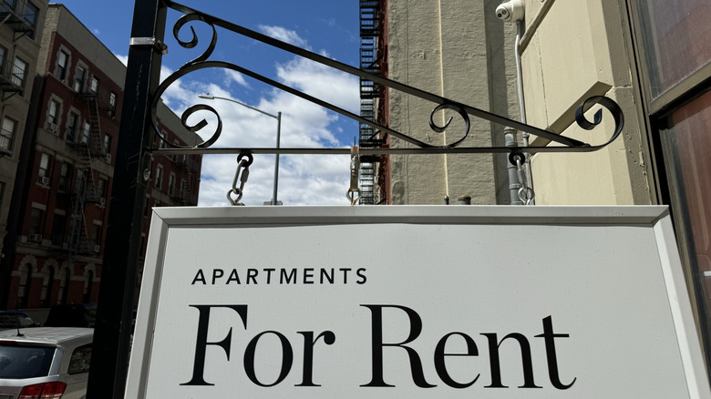 a sign on city street that reads: apartments for rent