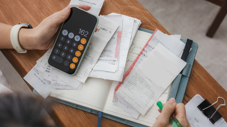 Woman with a calculator adding up receipts