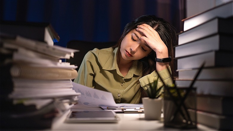 Person working, surrounded by paperwork