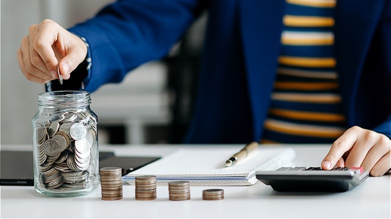 Person adding coins to jar