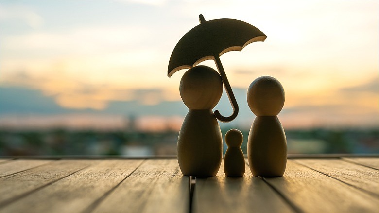 Family figurines holding umbrella