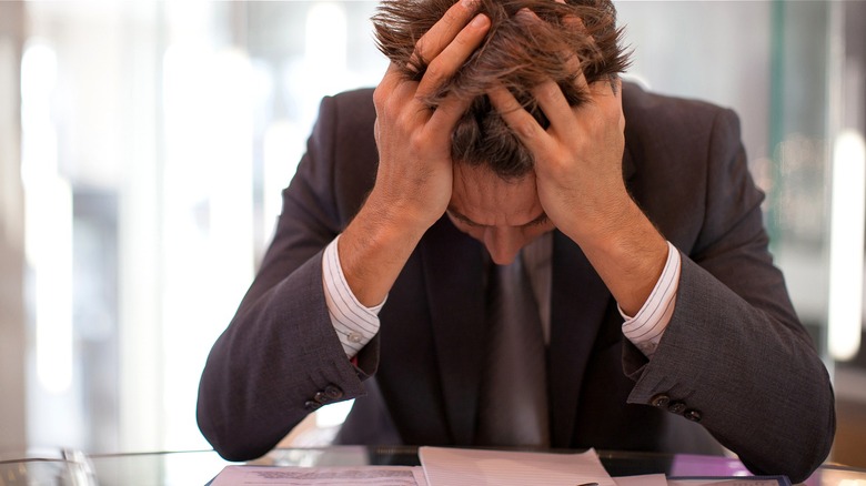 Person holding head in hands