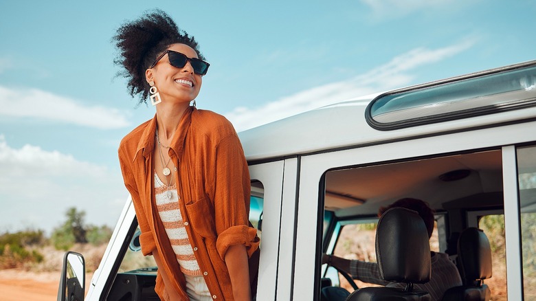 Person smiling, leaning out car