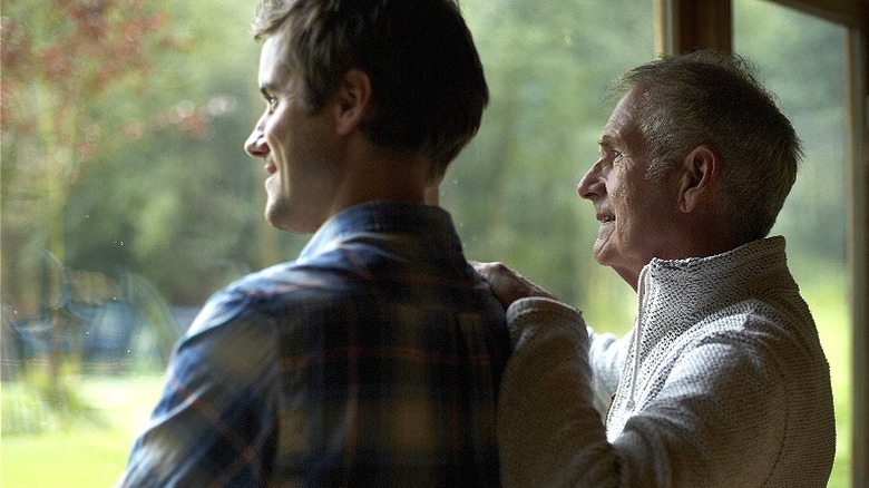 Father, adult son at window