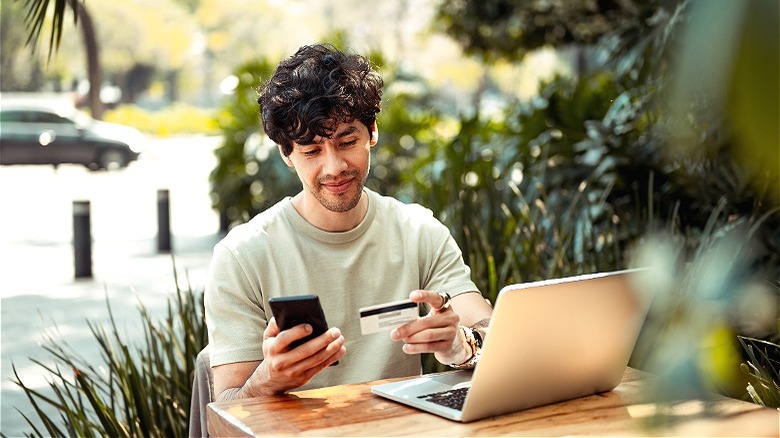 Person holding smartphone, credit card