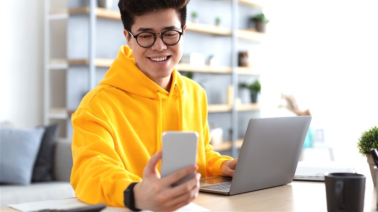 Person smiling, looking at phone