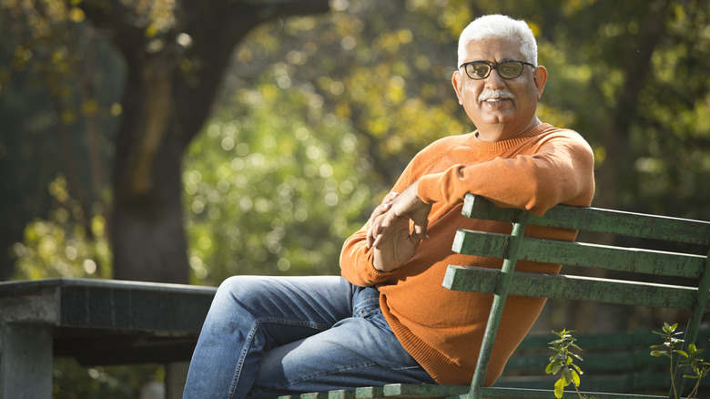 retired man sitting on park bench