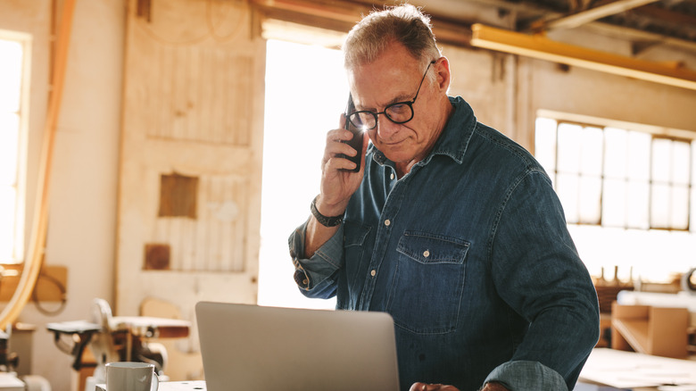 Old man with laptop and phone