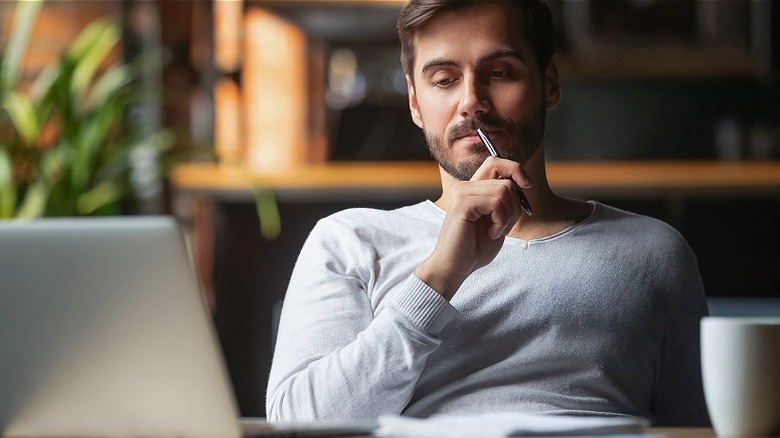 Person looking at computer pensively