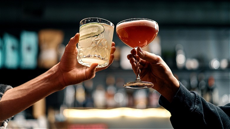 Two people clinking their cocktails