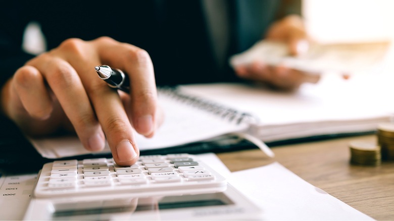 Person with pen making calculations