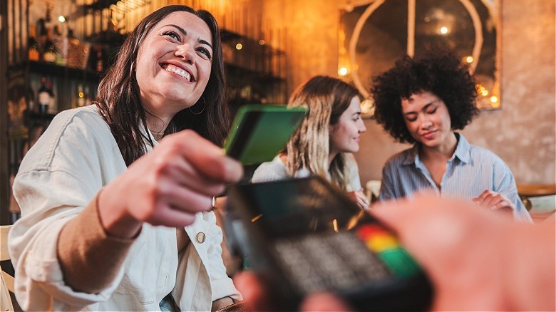 Person smiling, paying for dinner