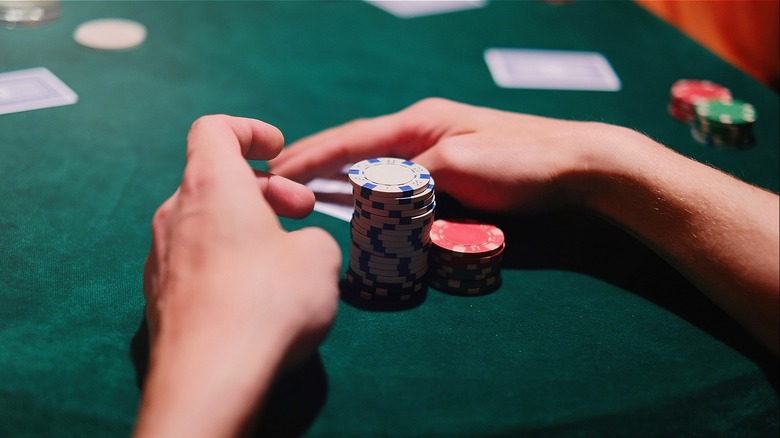 Card player holding gambling chips